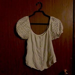 White blouse type of shirt with puffy shoulder sleeves. Buttons don’t unbutton.